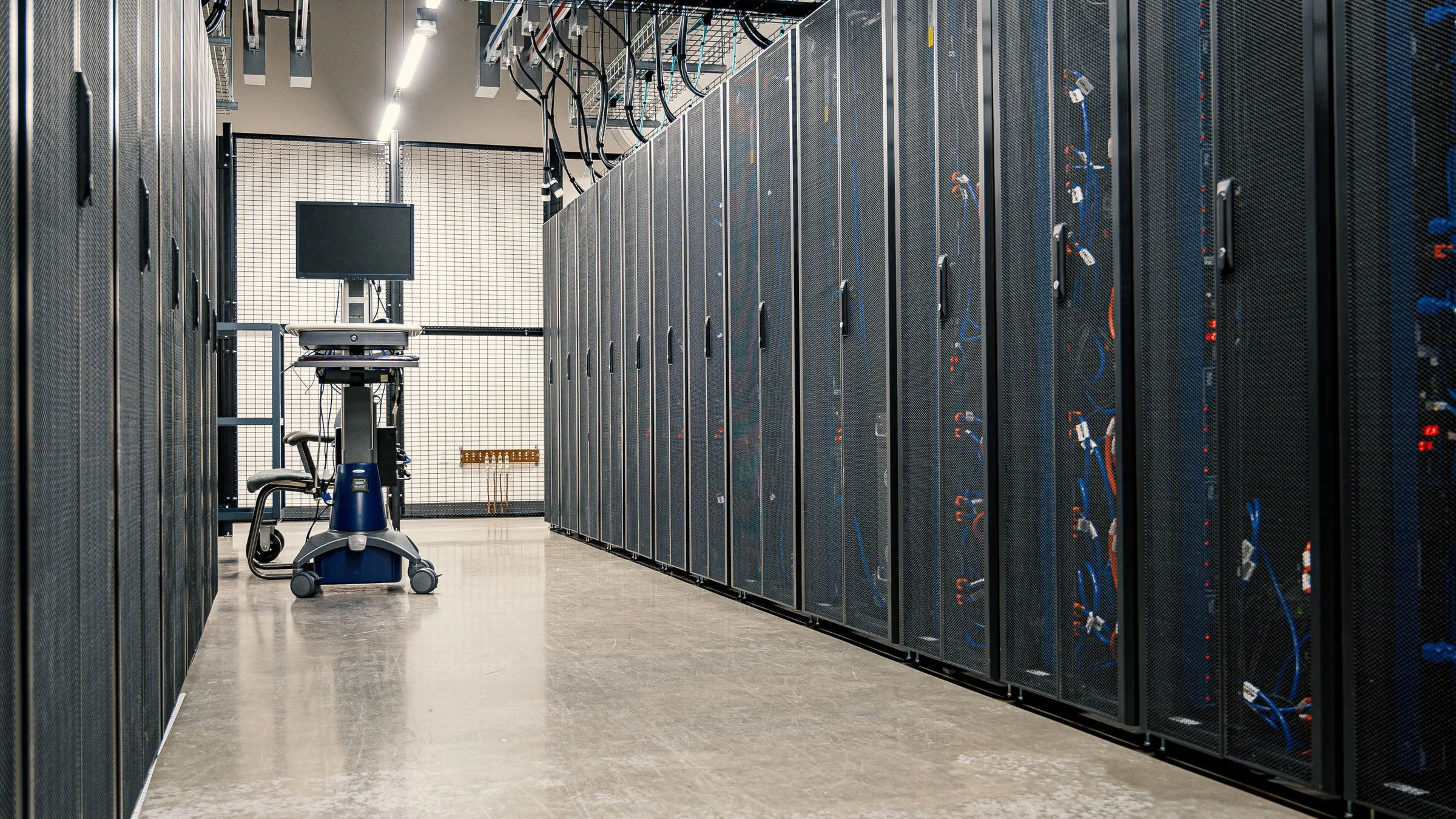 A real data center aisle with server racks, used to discuss AI infrastructure electricity demand and utility bill pressure