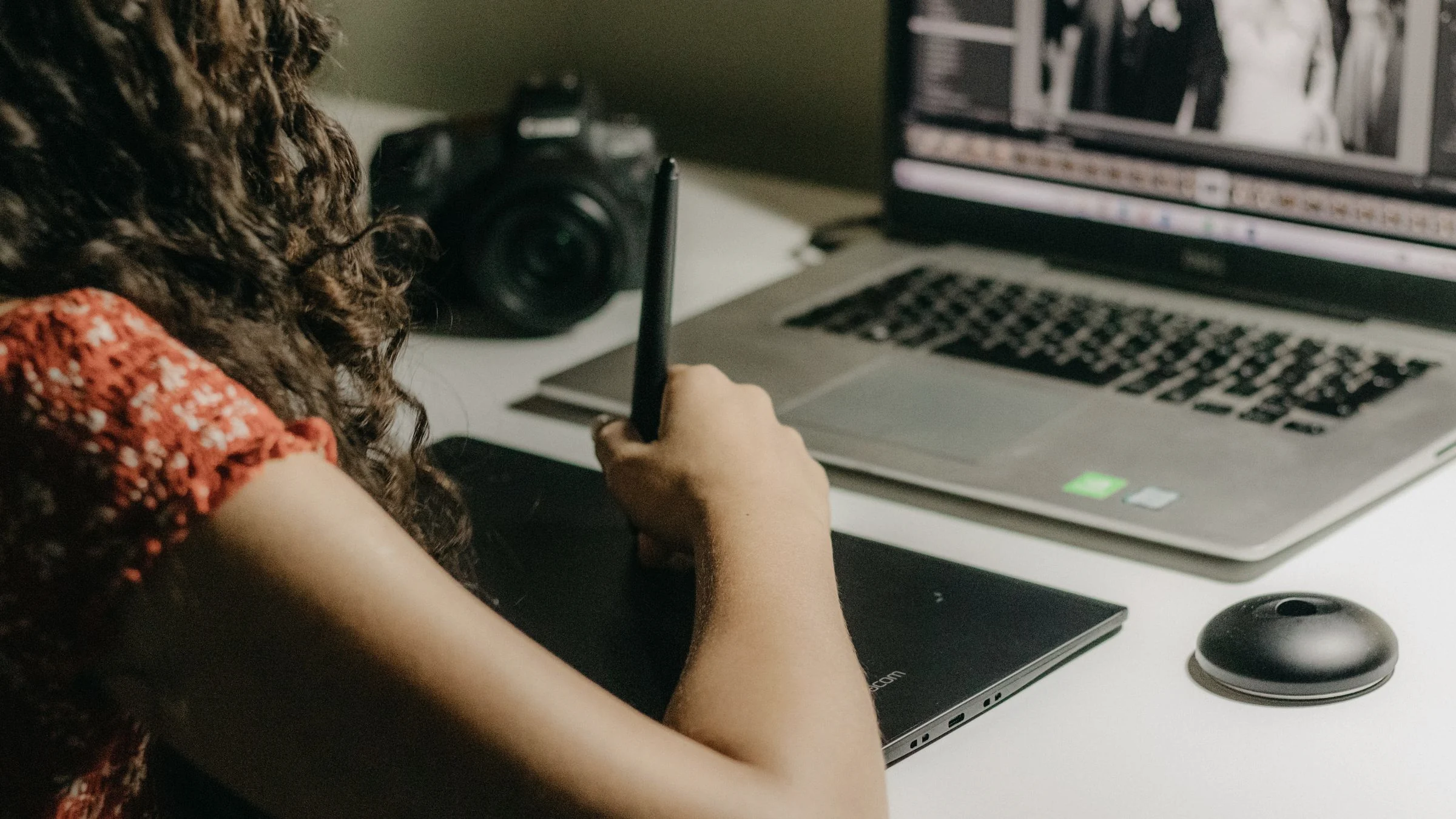 A person uses a pen tablet beside a laptop while reviewing visual work, used as a realistic production scene for an AI image generation quality guide