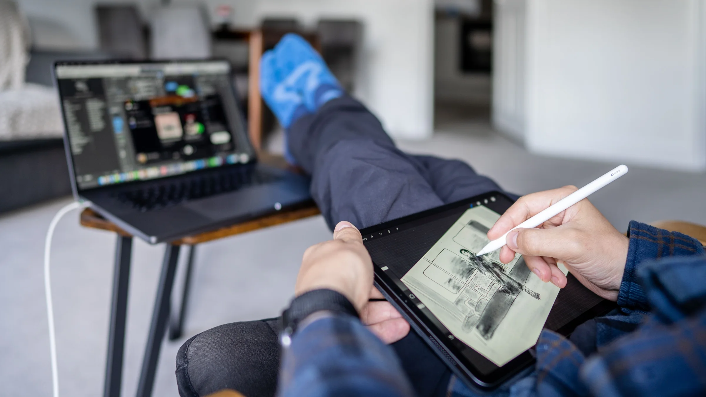A person draws on a pen tablet beside a laptop, used as a realistic work scene for choosing AI image generation tools
