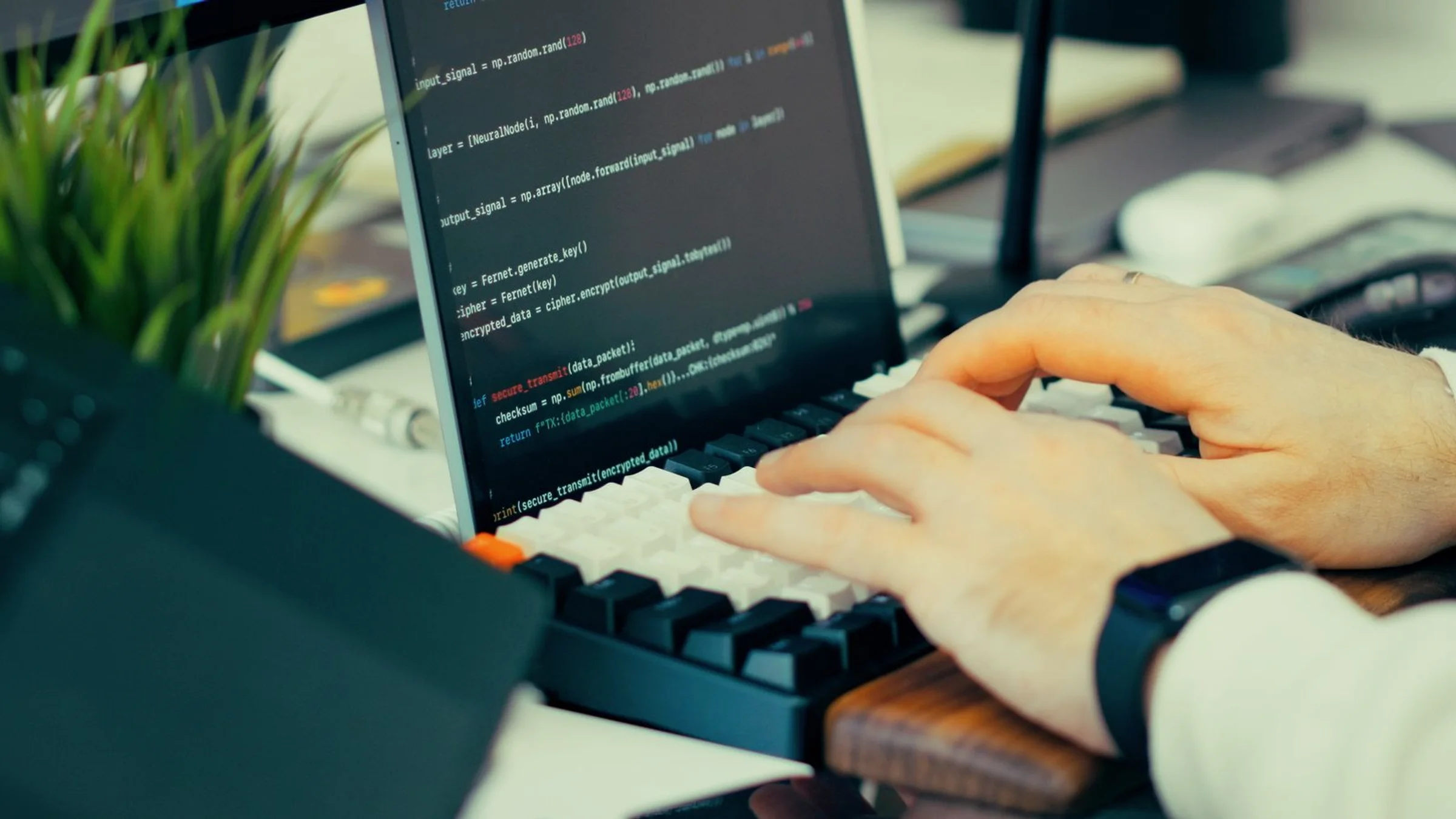 Developer typing at a workstation with code visible on multiple screens, used for a Google Agents CLI workflow article