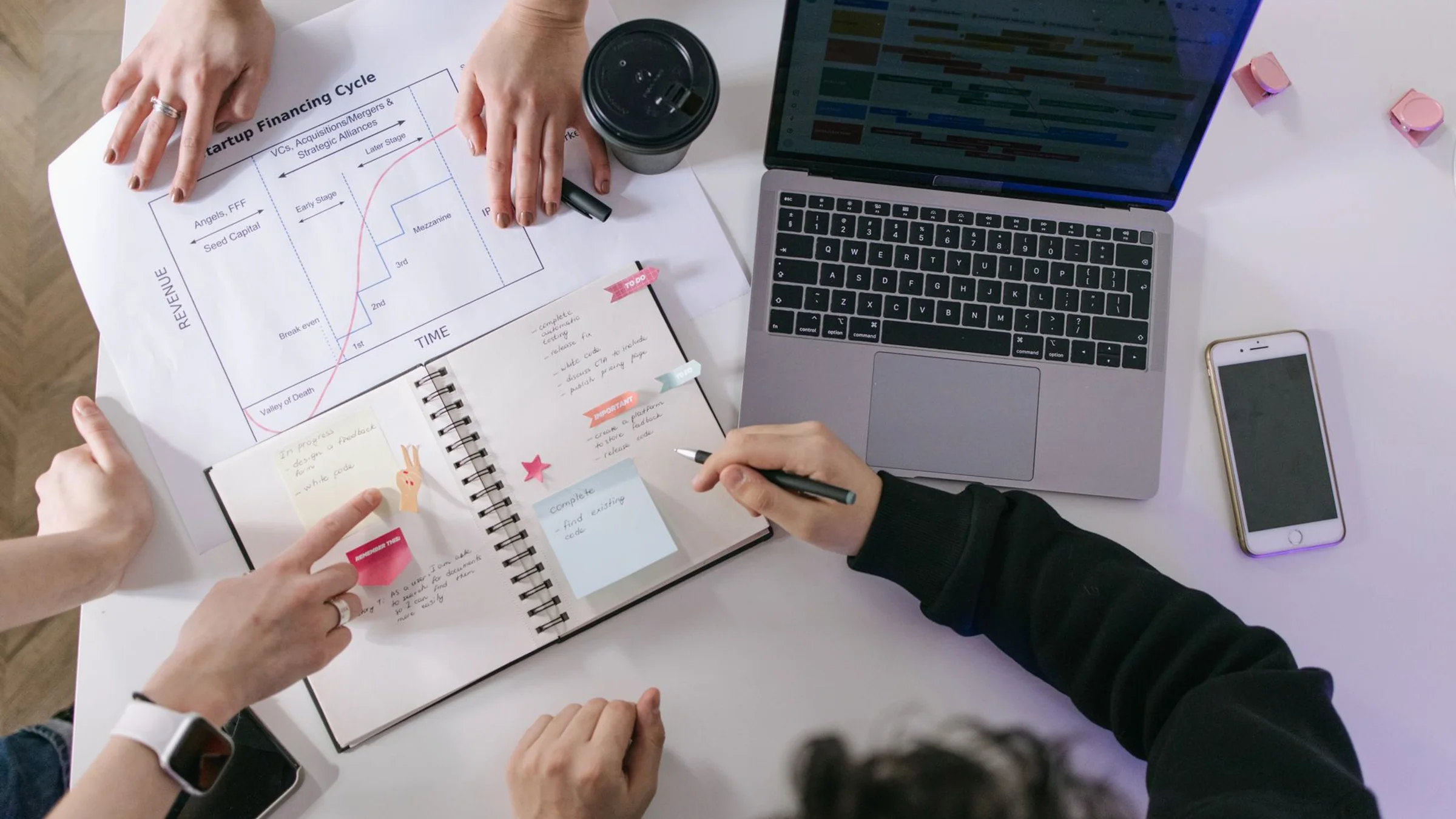 A real work table with laptops, notes, process sketches, and documents used to plan a Notion AI agent workspace